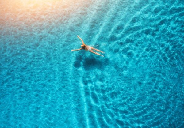 A person swimming in the ocean with their arms out.