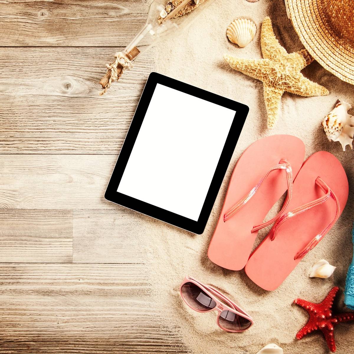 A tablet and some sandals on the beach