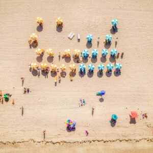 A beach with many people and umbrellas on it