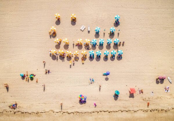 A beach with many people and umbrellas on it